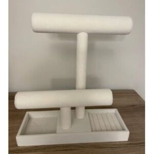 White jewelry stand with gold detailing.